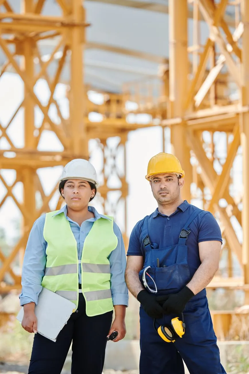 Equipe de engenharia com colete e capacete conferindo documentação em vistoria
